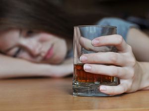 depressed woman with alcohol in her hand