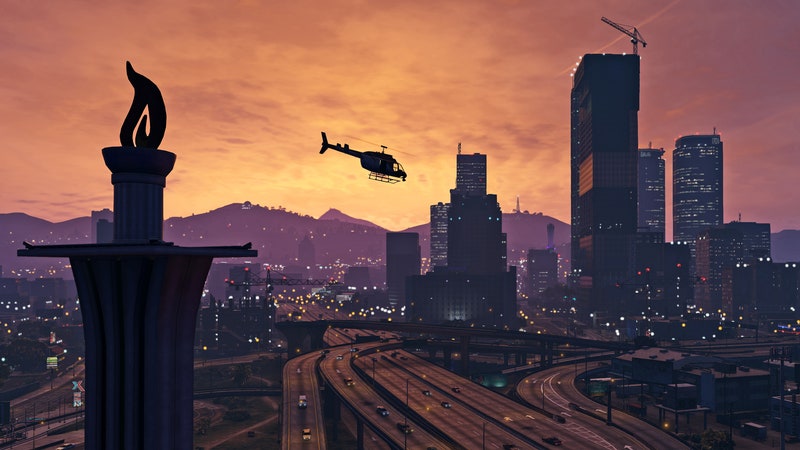 Screenshot of Rockstar Games' Grand Theft Auto V featuring a helicopter flying above city at sunset