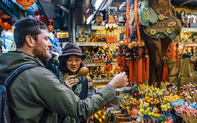 man and woman looking at trinkets while traveling