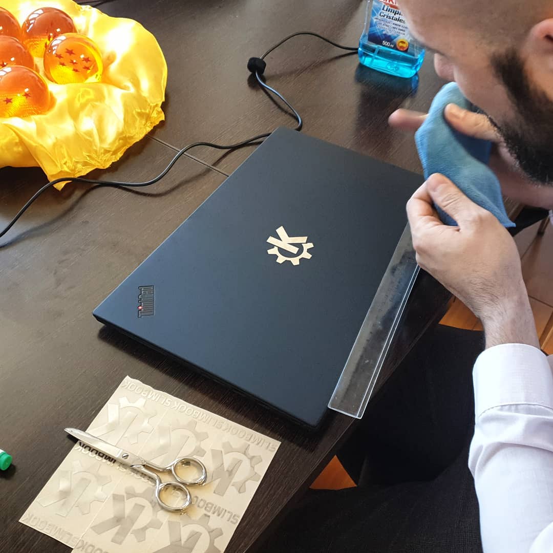 Alejandro López attaching a silver KDE sticker to my new laptop