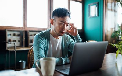 person stressed out while working on their laptop