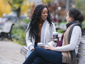 friends talking over coffee in the park