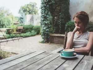 Grieving woman sitting thoughtfully in the back yard