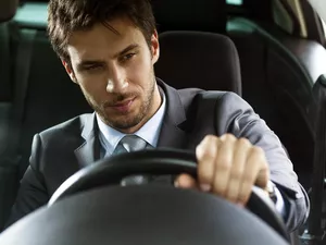 close up of a handsome young businessman driving car