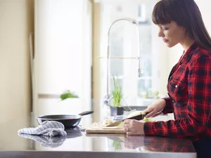 woman cutting onion on kitchen counter