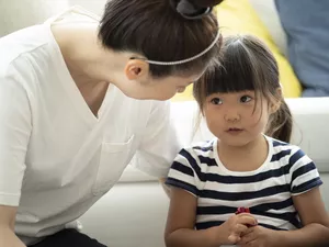 Mother talking to her daughter on the floor