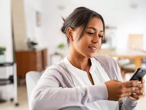 African mid woman using smartphone at home