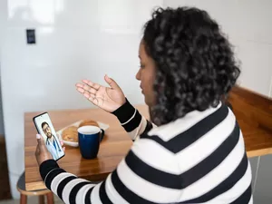 Mid adult woman on a video call with a doctor at home