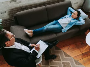 High Angle View Of Men Sitting On Sofa At Home