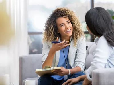 Smiling therapist talks with young woman