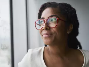  Portrait of cheerful businesswoman looking out window in conference room