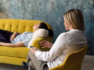 Woman lying on couch with therapist.