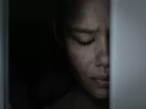 A scared woman depressed hiding in the closet ashamed and frightened.