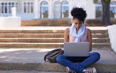 Student using laptop outside on college campus