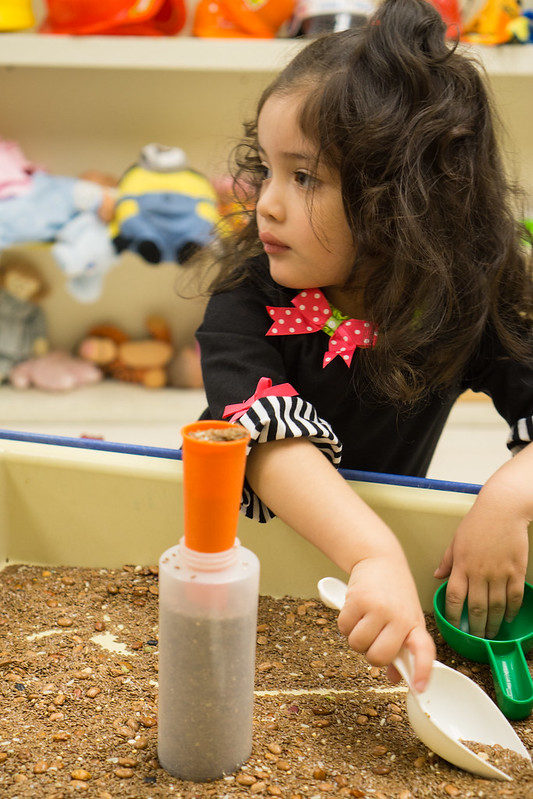 Girl playing at sand table