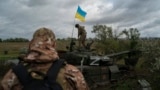 A Ukrainian national guard serviceman stands atop a destroyed Russian tank in an area near the border with Russia, in Kharkiv region, Ukraine, Sept. 19, 2022.