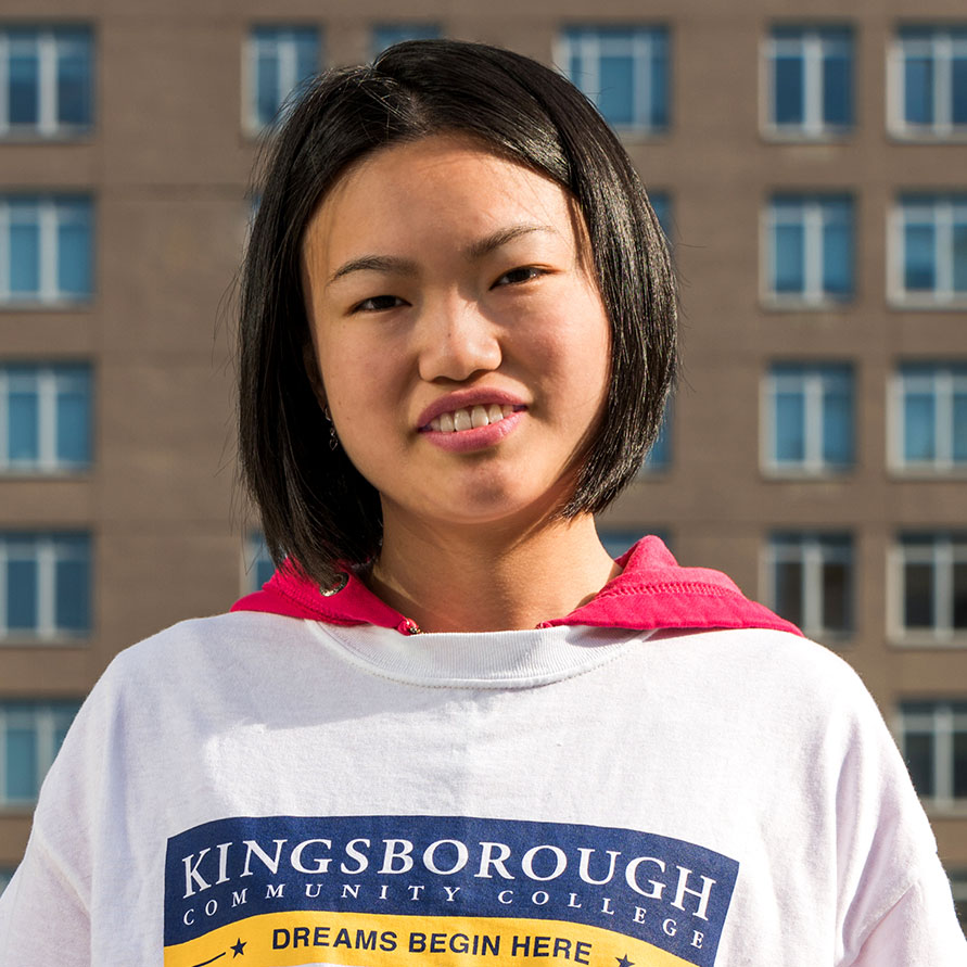 Kingsborough Community College student Zixing Zhuo with t-shirt showing school logo