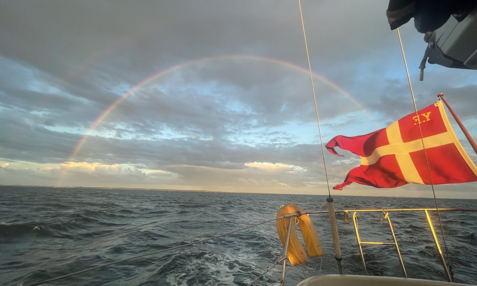 Sailing boat on sea with rainy sky and rainbow. Isefjord, Denmark. Photo contributed by Brogaard to the WordPress Photo Directory.