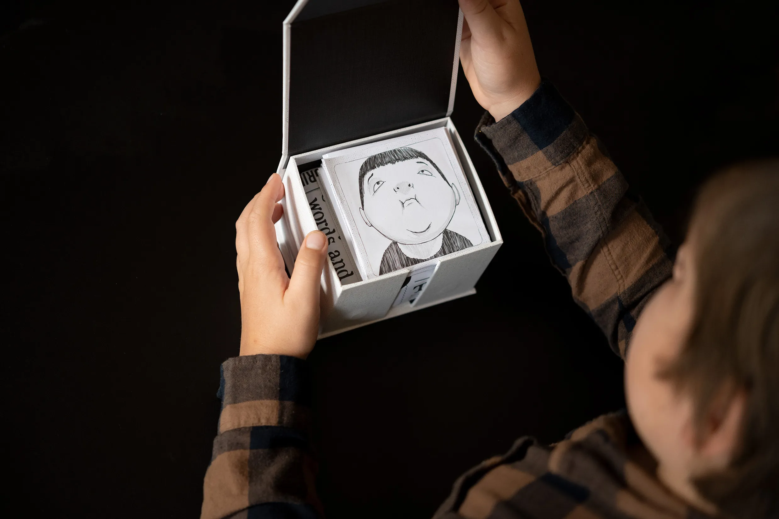 Image of a boy's hand opening the face cards by quirky kid clinic