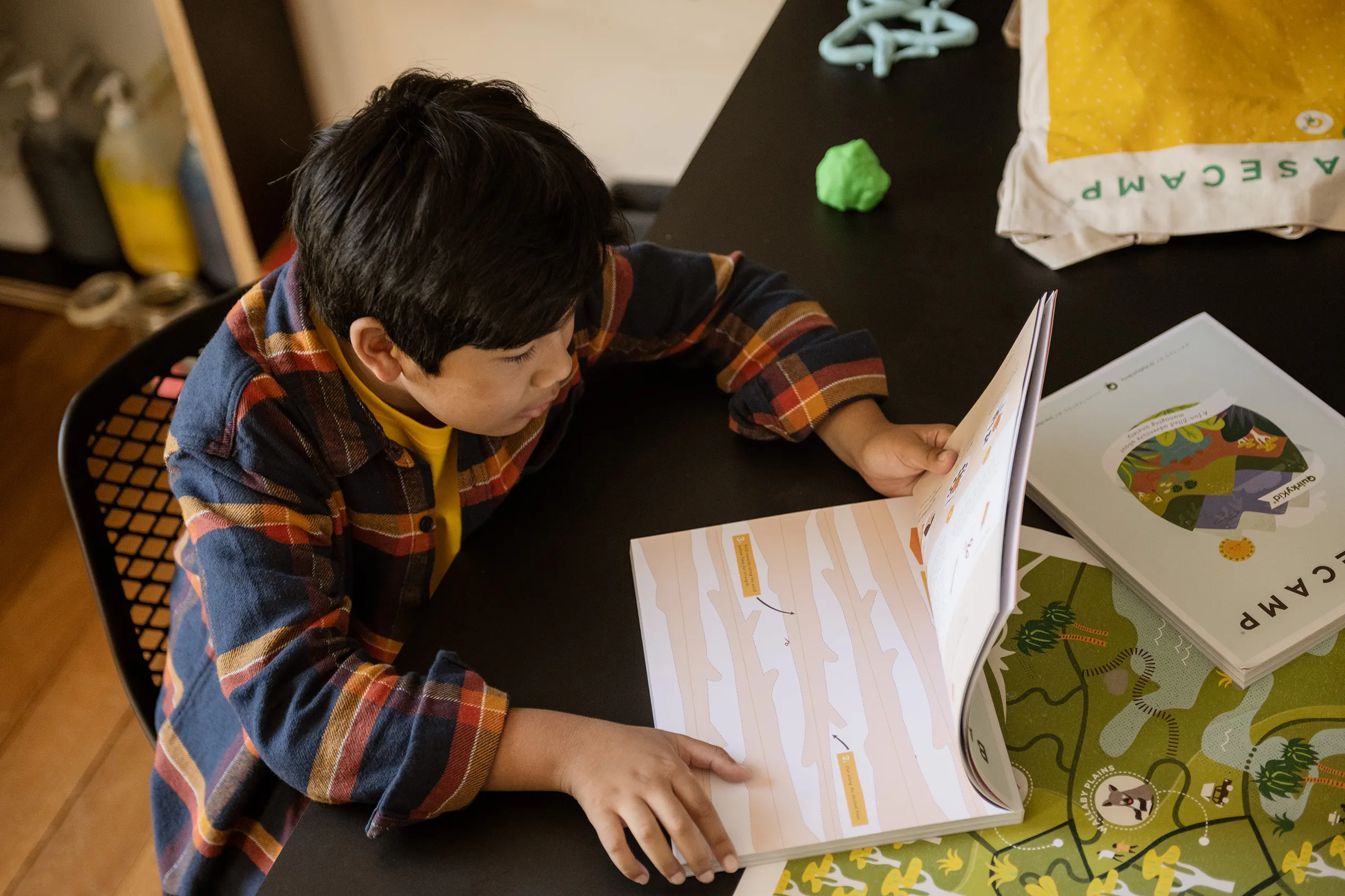 Image a a boy reading the basecamp anxiety book by quirky kid