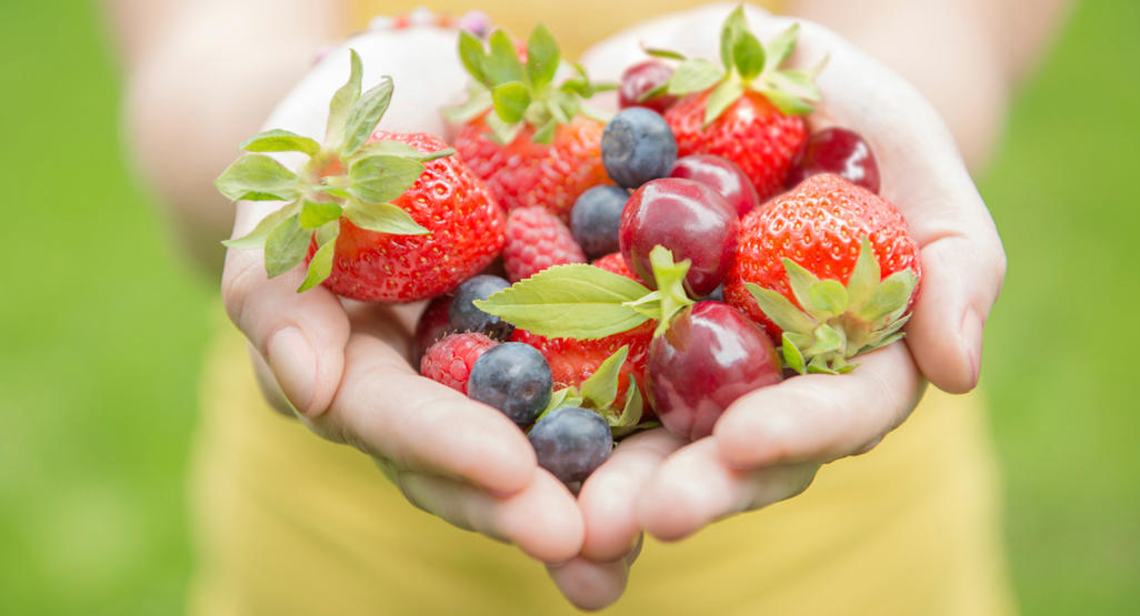 mixed berries being held by a woman who is trying to conceive