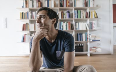 Smiling young man at home looking sideways