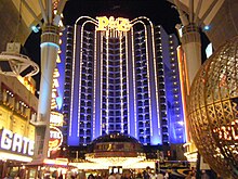 The entrance to a lit-up high building at night.