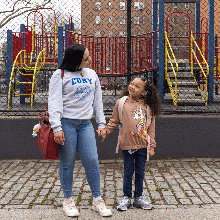 A CUNY student holding her daughter.