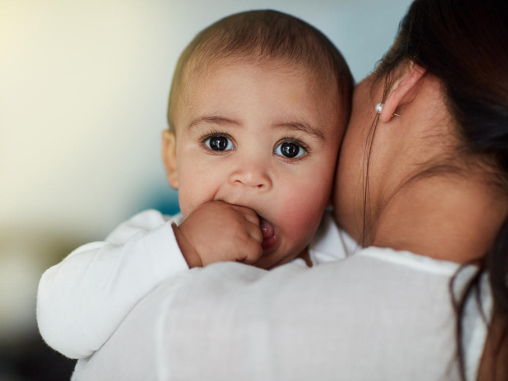 bebê com a mão na boca