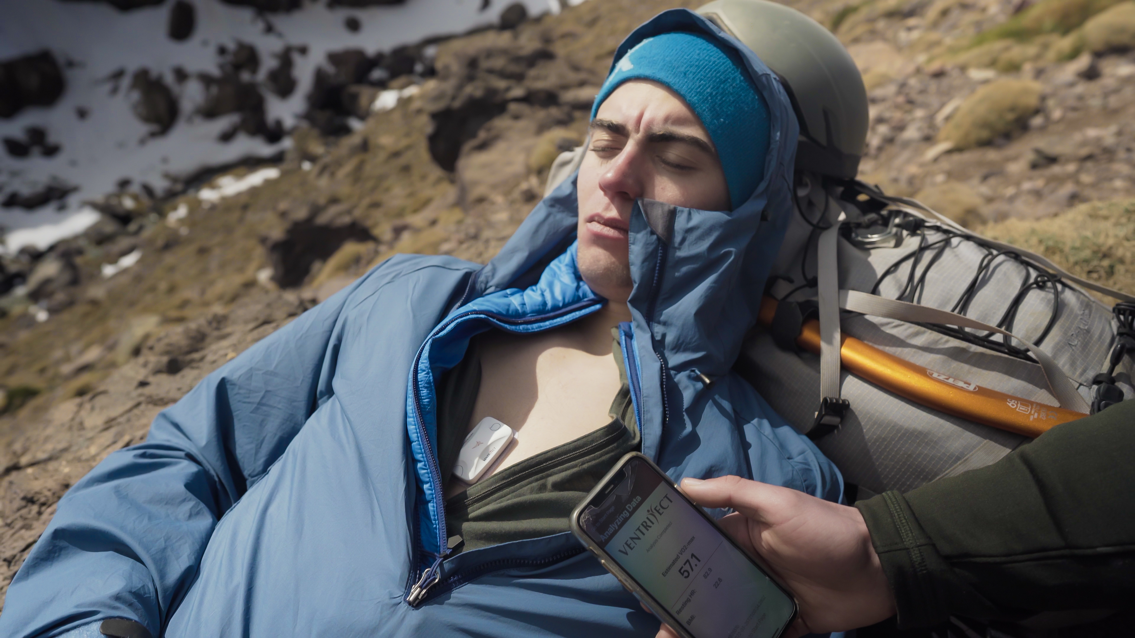 Student lays on their back with a seismofit on their chest, another student observes a screen