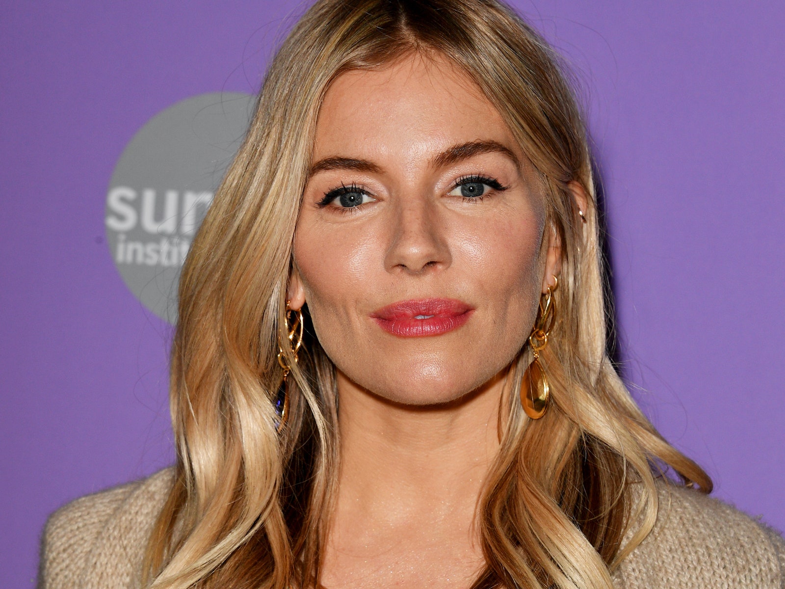 Image may contain Hair Blonde Person Head Face Sienna Miller Adult Happy Smile Lipstick and Cosmetics