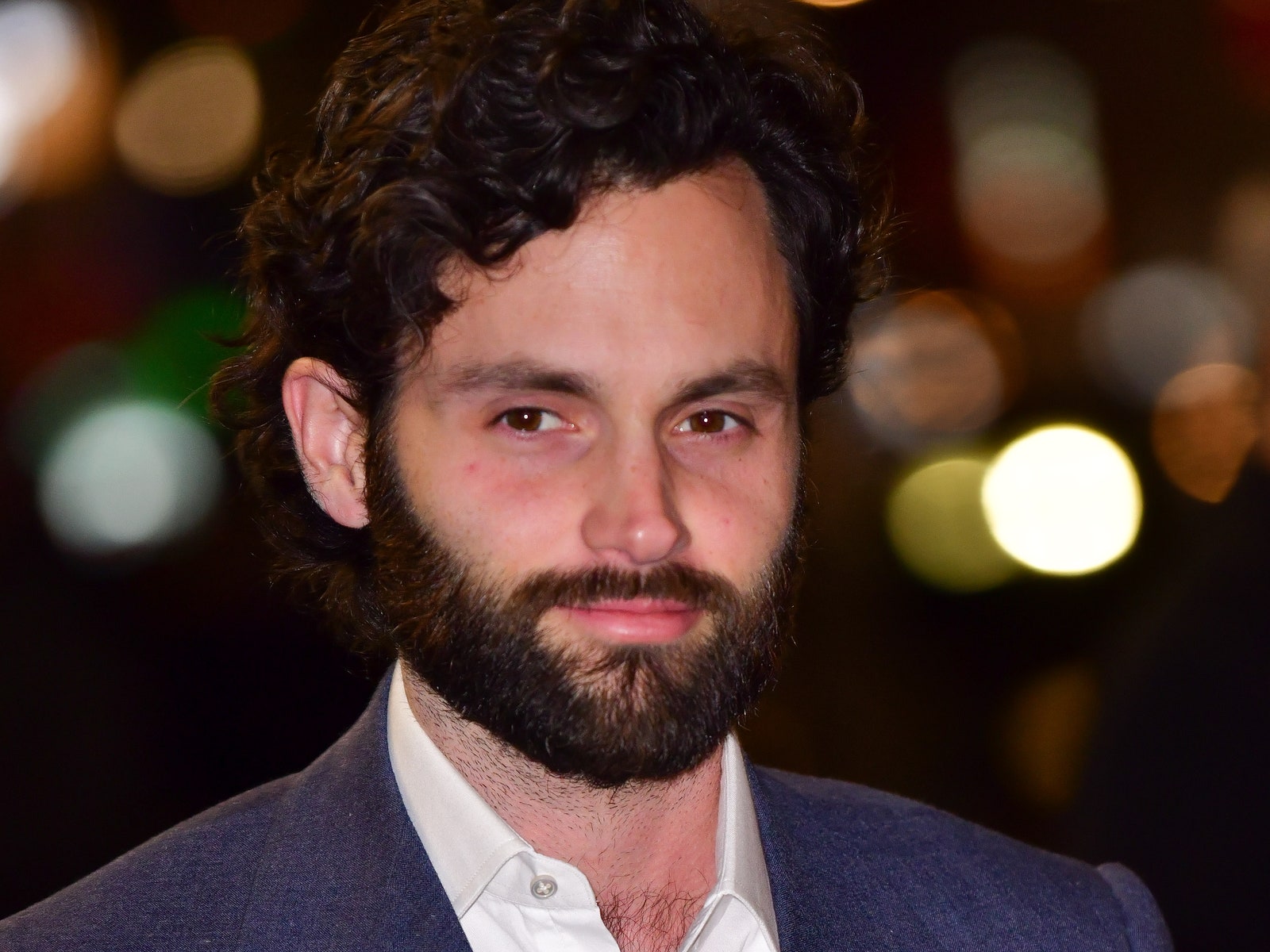 Image may contain Head Person Face Beard Coat Blazer Clothing Jacket Penn Badgley Adult Suit and Formal Wear