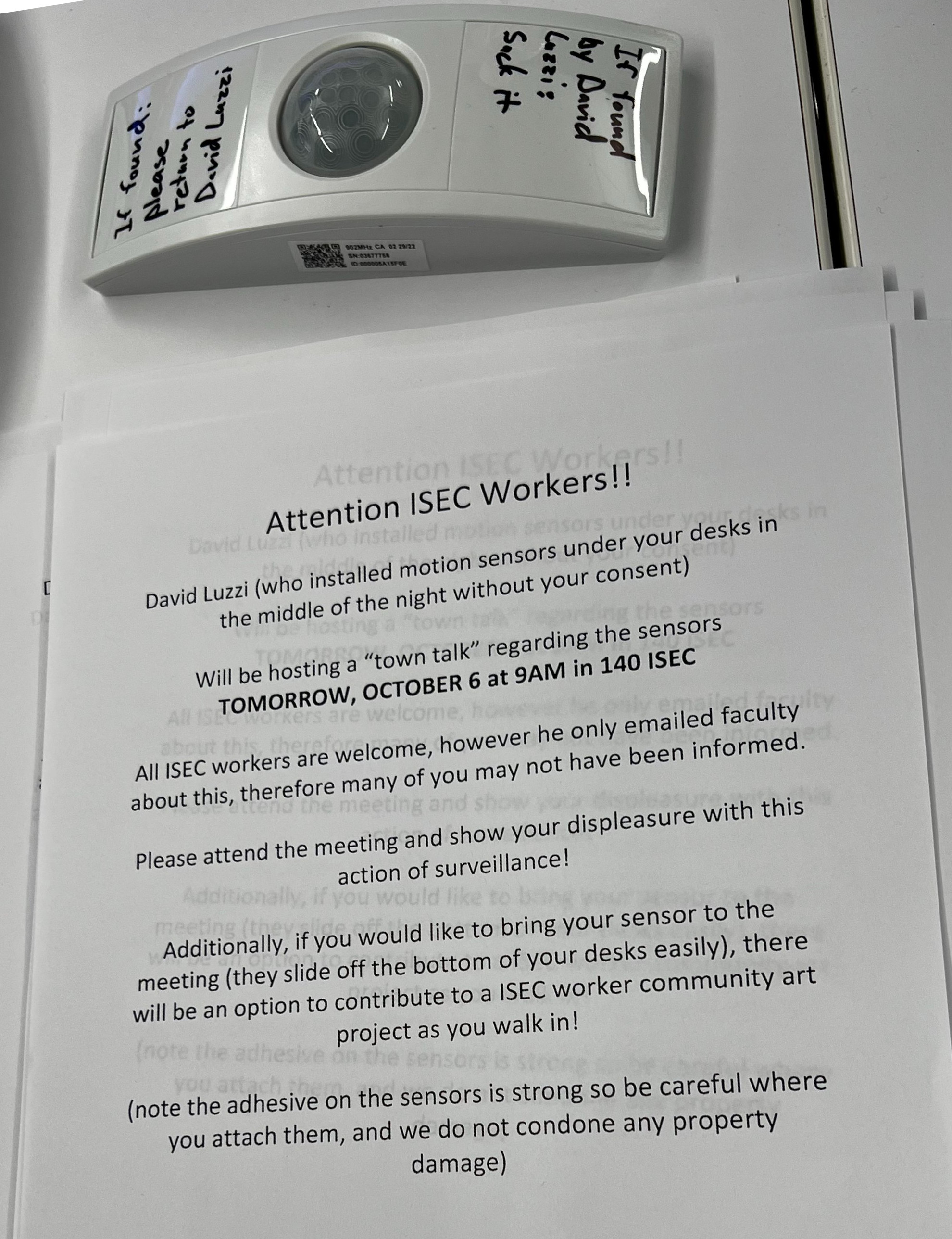 A flier inviting ISEC grad students to attend an unadvertised 'listening session' with vice-provost David Luzzi. It is surmounted with a sensor that has been removed from beneath a desk and annotated in Sharpie to read: 'If found by David Luzzi suck it.'