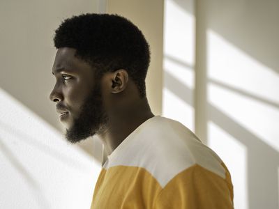 Side portrait of a young African American man looking at the window