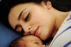 Mom Holding Newborn Baby in Hospital Bed