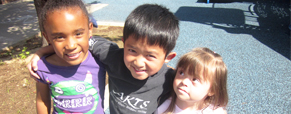 three preschool children with arms around each others shoulders