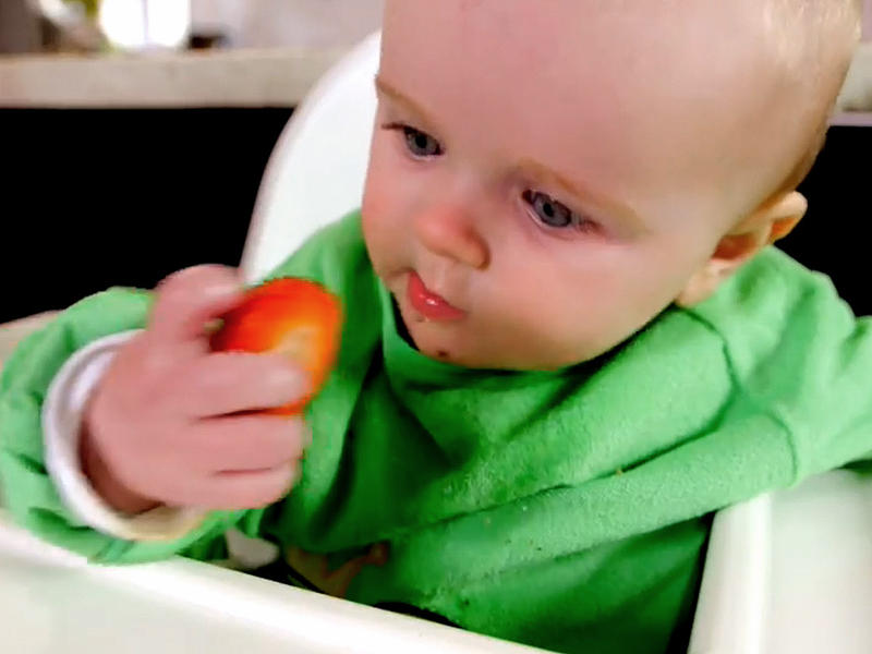 Baby isst ein weiches Stück Gemüse