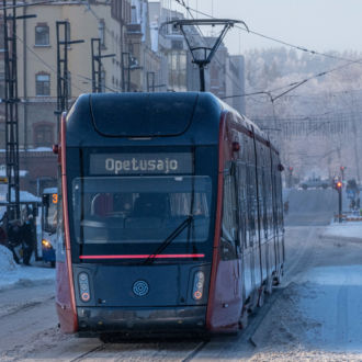 A tram goes down a snow-covered street.