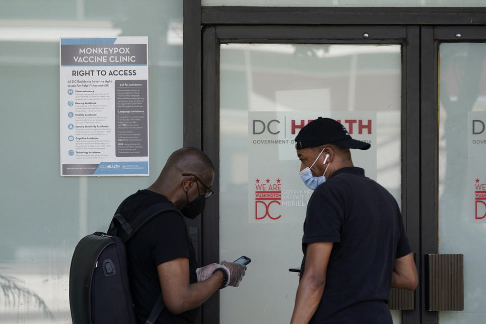 Two people gather outside a DC Health monkeypox vaccine clinic.