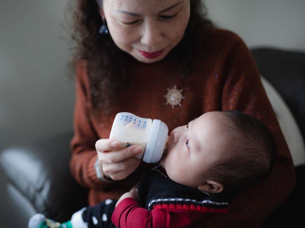 Grandmother bottle feeding a baby 