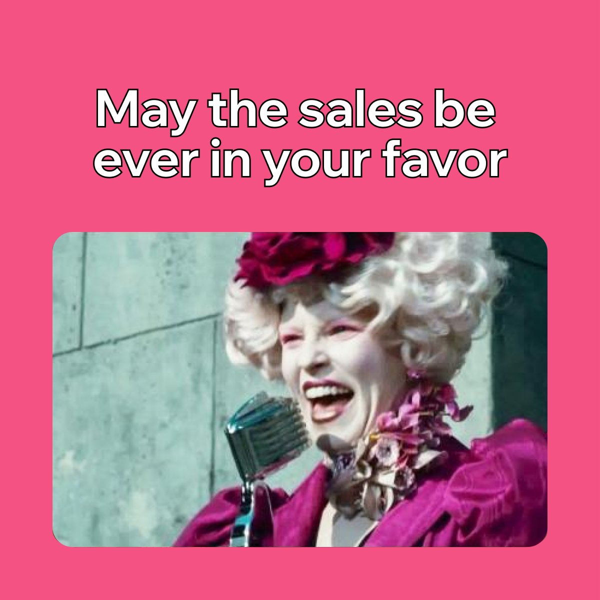 Effie Trinket from The Hunger Games speaking into a microphone. 

Text above on a pink background reads: "May the sales be ever in your favor"