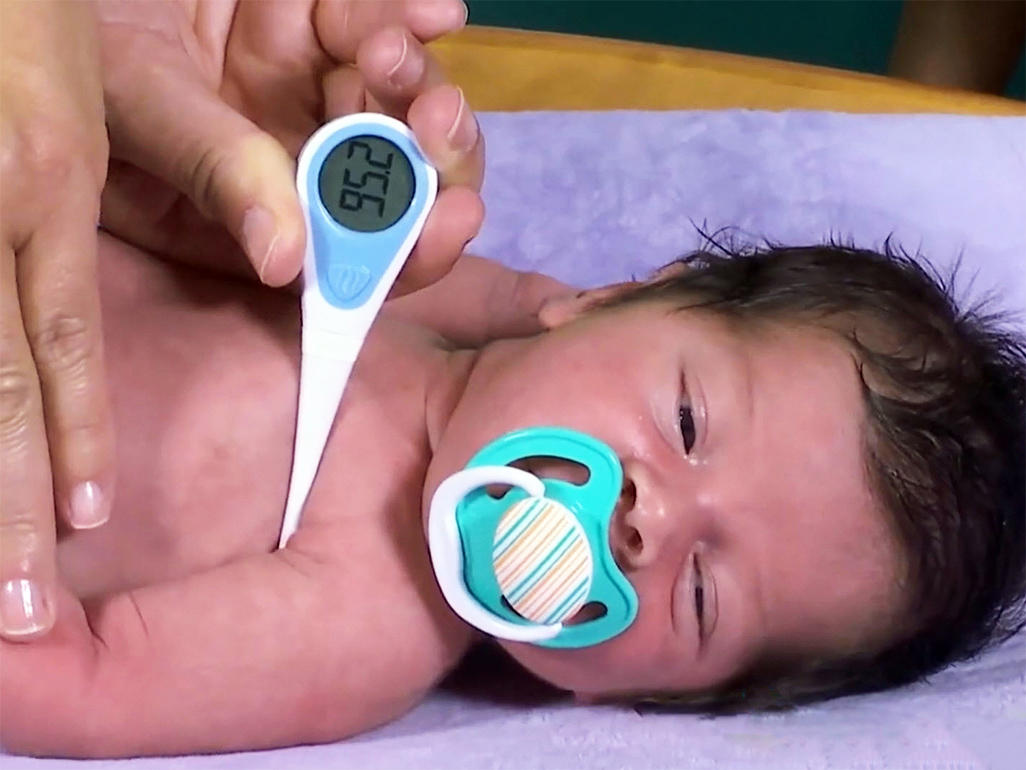 bebé con termómetro y chupete