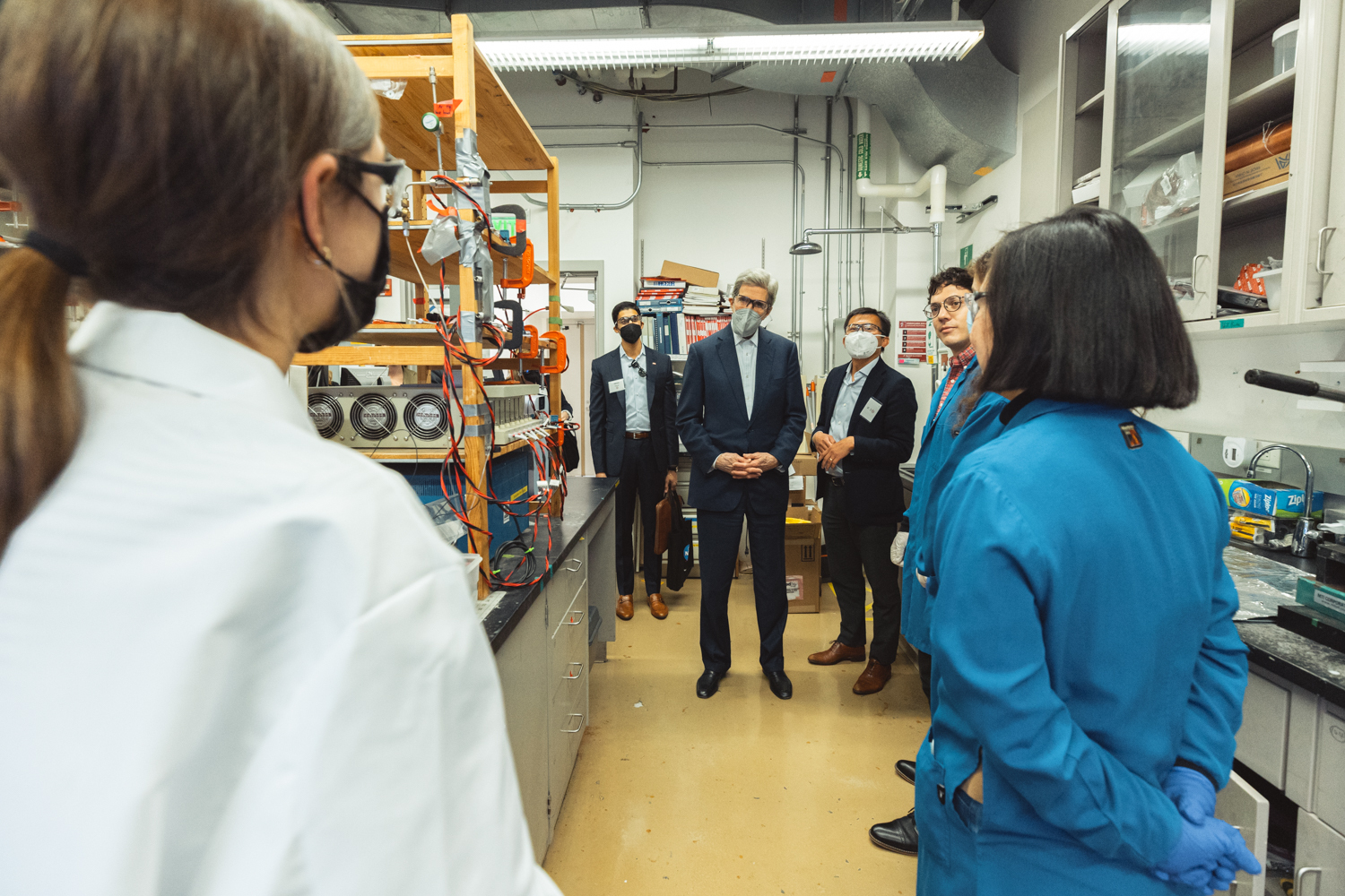 John Kerry talks with scientists while touring a lab on campus