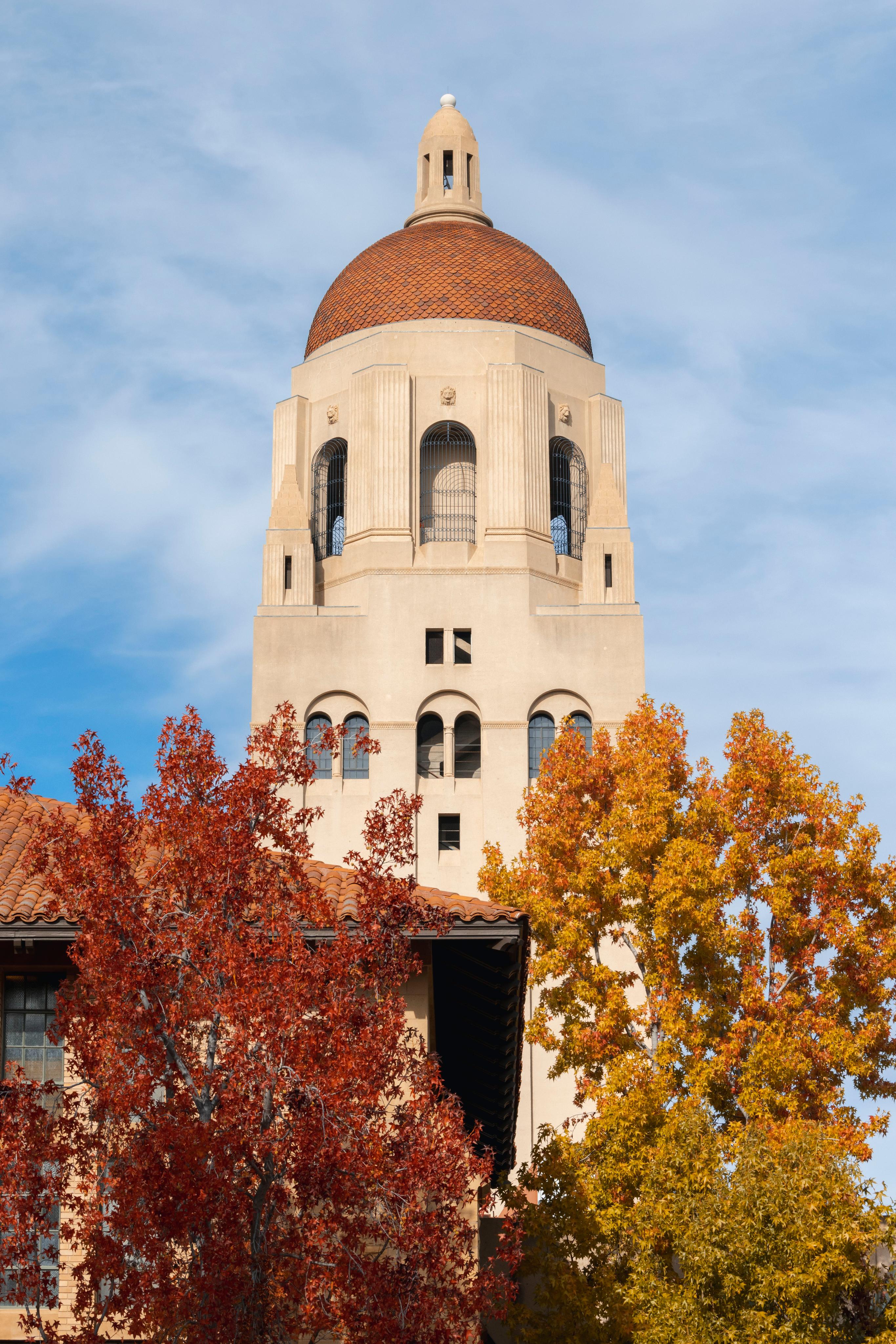 Hoover Tower peeks out behind fall trees