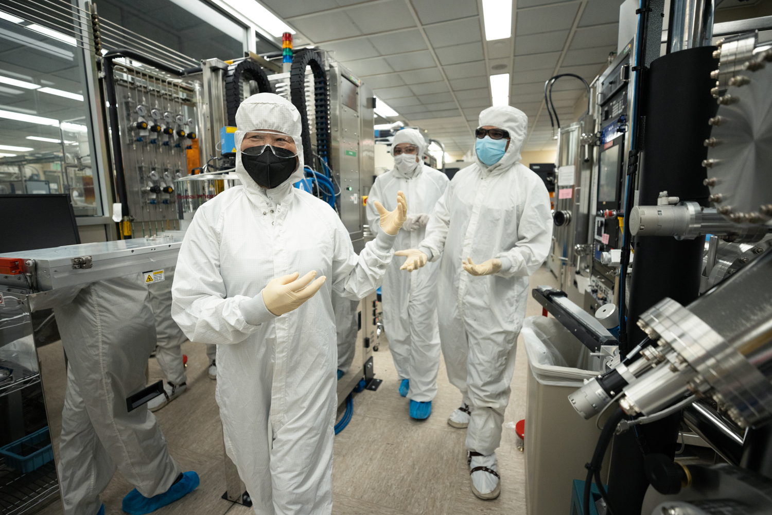 People walk through the Stanford Nanofabrication Facility in Tyvek suits