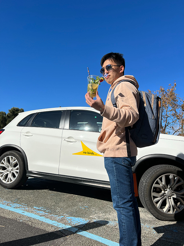 Huanyi pictured on an outing, stood next to a white car.