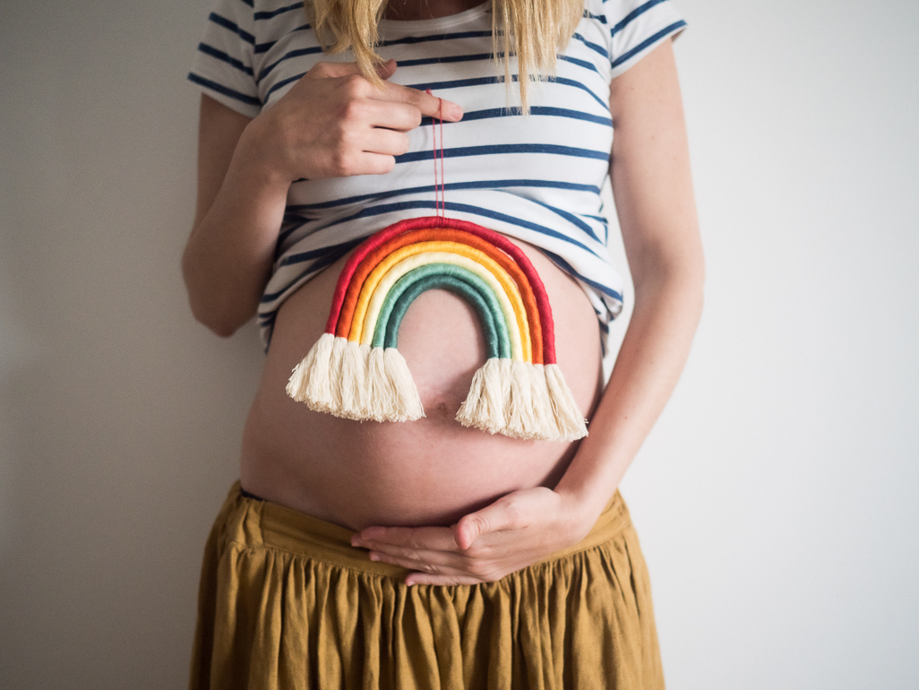 pregnant woman holding a customised rainbow ornament