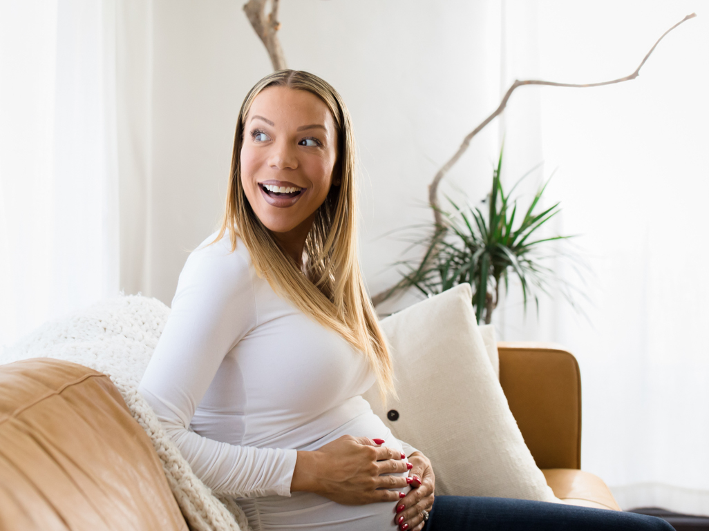 happy pregnant woman with hands on belly