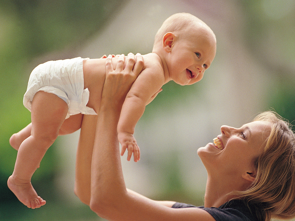 A mother lifting a baby in the air