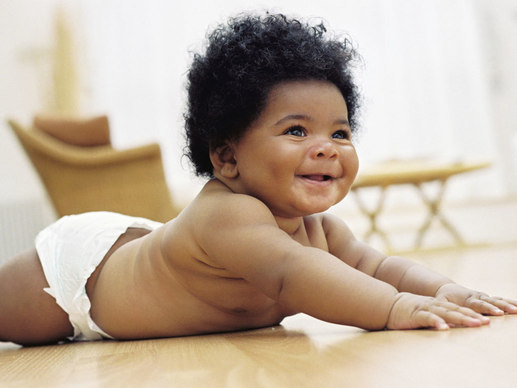 baby lying on its stomach laughing